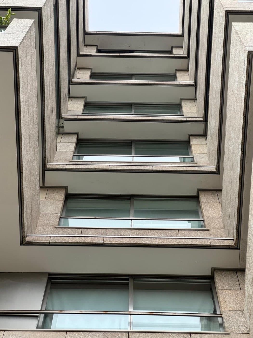 Fachada do edifício residencial vista em contrapicado, com o alinhamento das varandas e caixilharias.