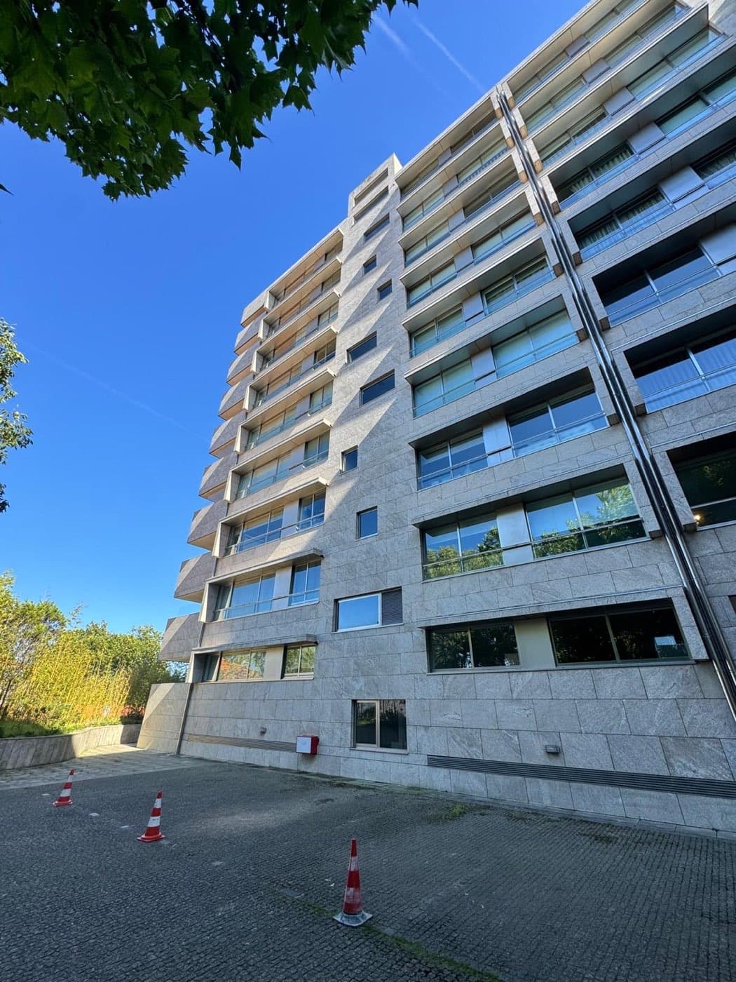 Alçado do edifício residencial em pedra inspecionado no Porto, com a zona de trabalhos delimitada.