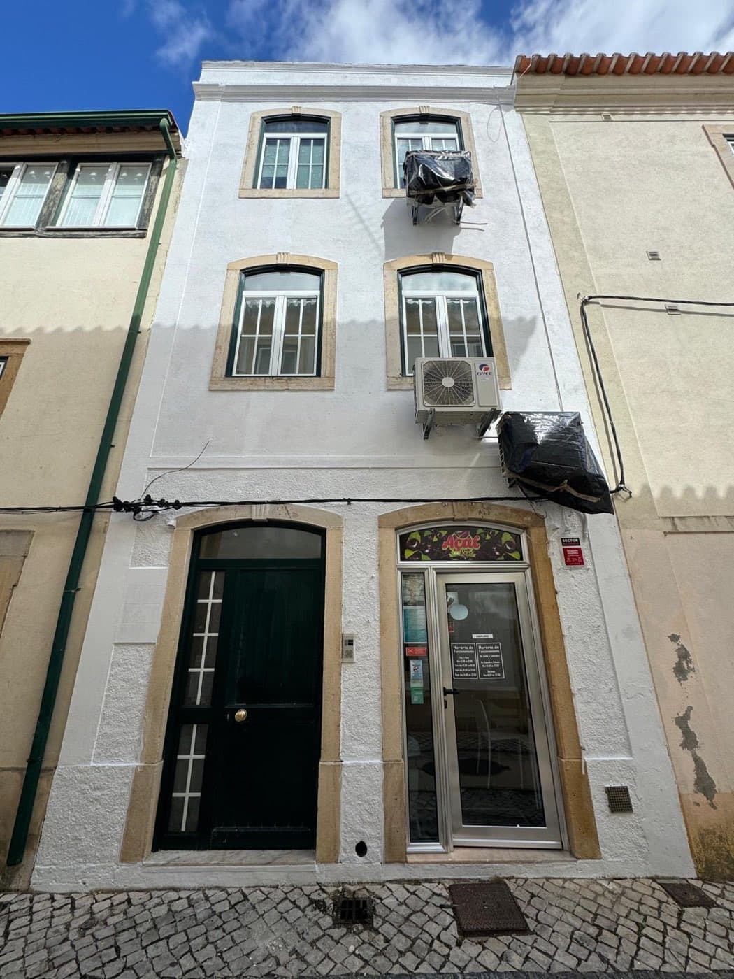 Fachada do edifício em Tomar durante a intervenção, já com o suporte recuperado e primário aplicado.